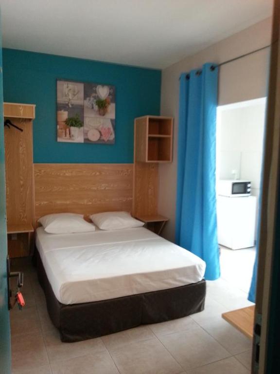 a bedroom with a bed with a blue wall at L'ANNEXE 66 , Saint Denis Centre Ville , à 200 m de la Rue Piétonne , du Petit Marché et du Leader Price , sur une rue calme, PARKING GRATUIT sur la rue in Saint-Denis