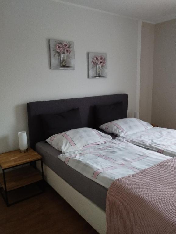 two beds in a bedroom with two pictures on the wall at Ferienwohnung Marita in Rietberg