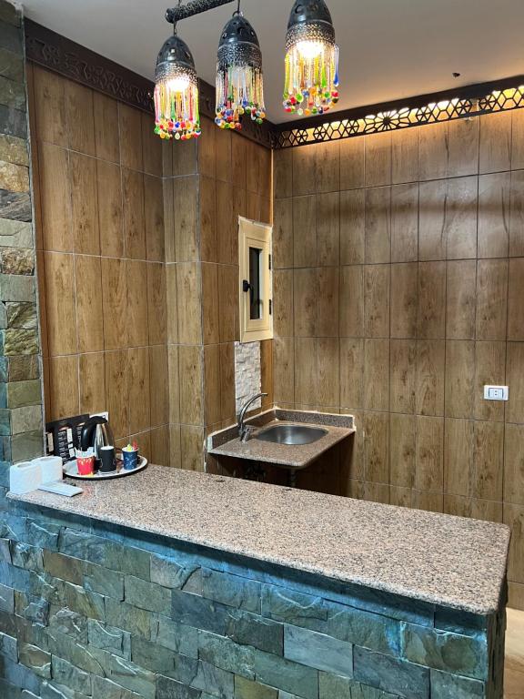 a kitchen with a sink and a counter with lights at Comfort Sphinx Inn in Cairo