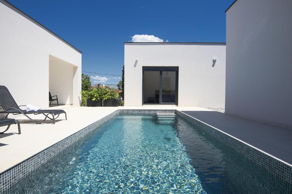 une piscine dans l'arrière-cour d'une maison dans l'établissement Villa Nauta - beautiful ground floor villa for 4 people with playground & sauna Pula, à Vintijan