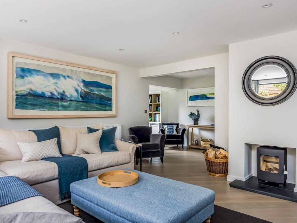 een woonkamer met een bank en een open haard bij Modern Stylish Bosham Home - Pass The Keys in Bosham