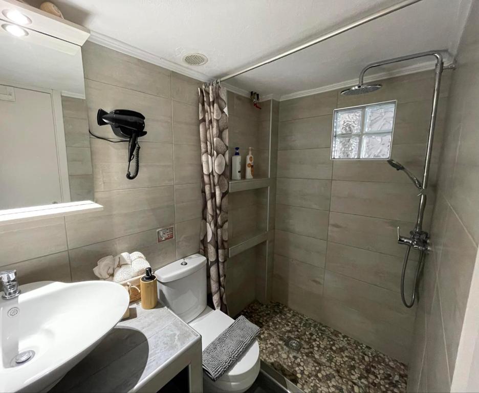 a bathroom with a sink and a toilet and a shower at V&Z Apartment Seaview in Ofrínion