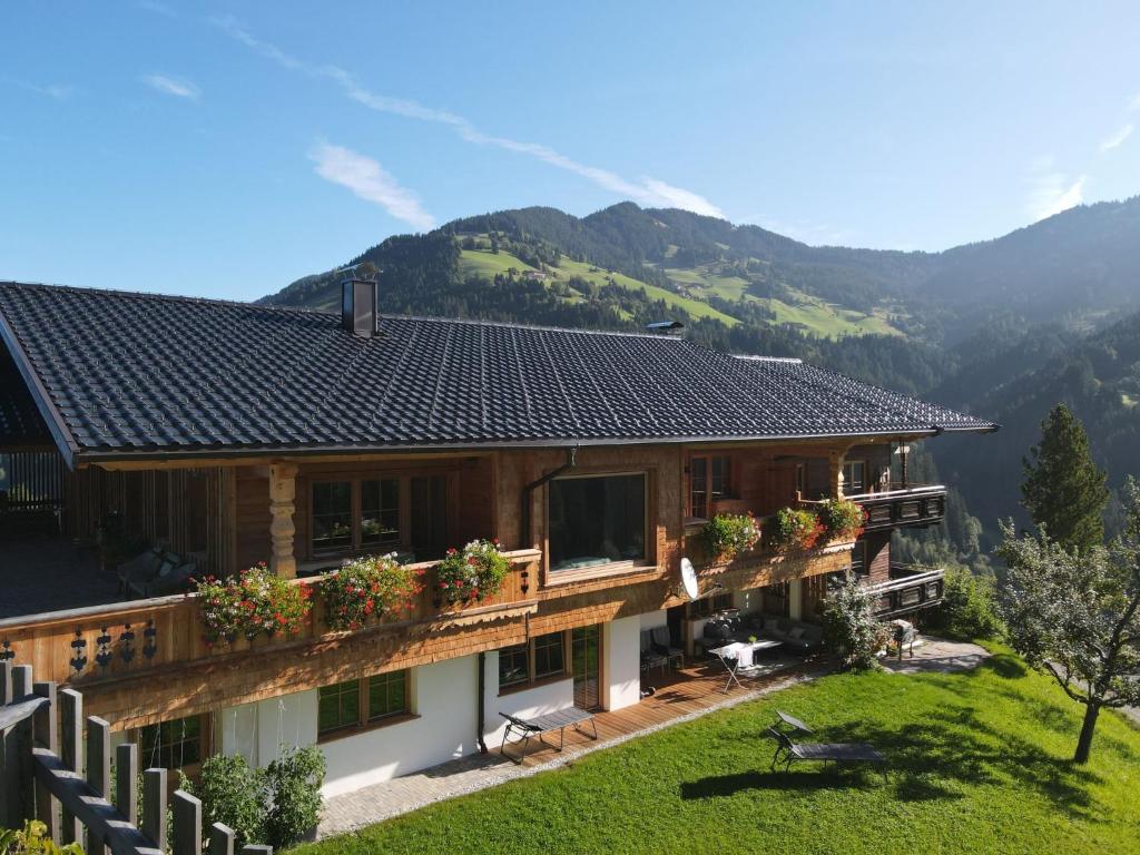 a house with a balcony and mountains in the background at Apartment Panorama Chalet Tirol by Interhome in Auffach