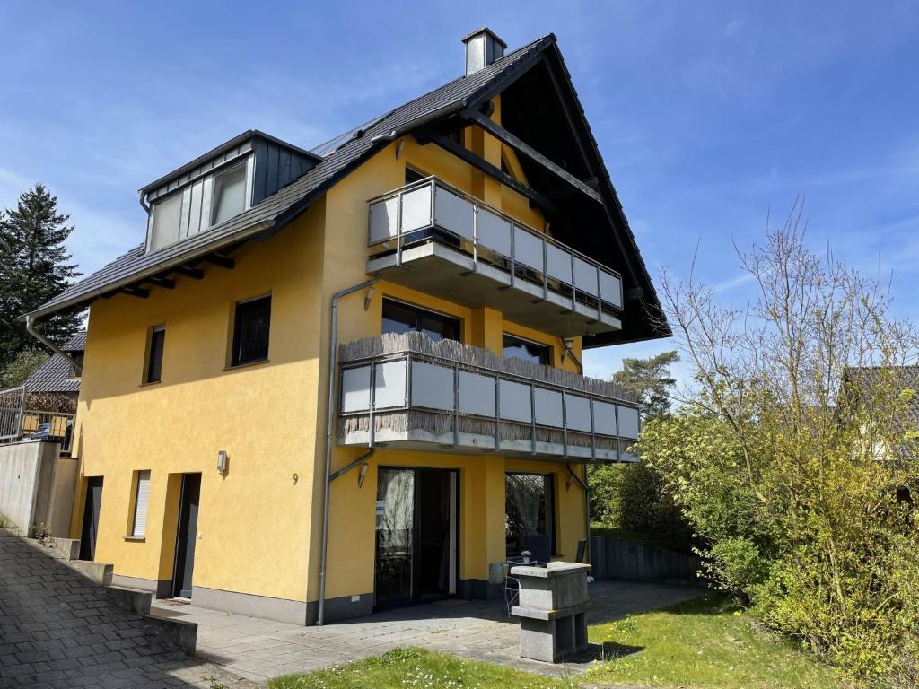 a yellow house with a black roof at Apartment Müritz Ferienpark Röbel-15 by Interhome in Röbel