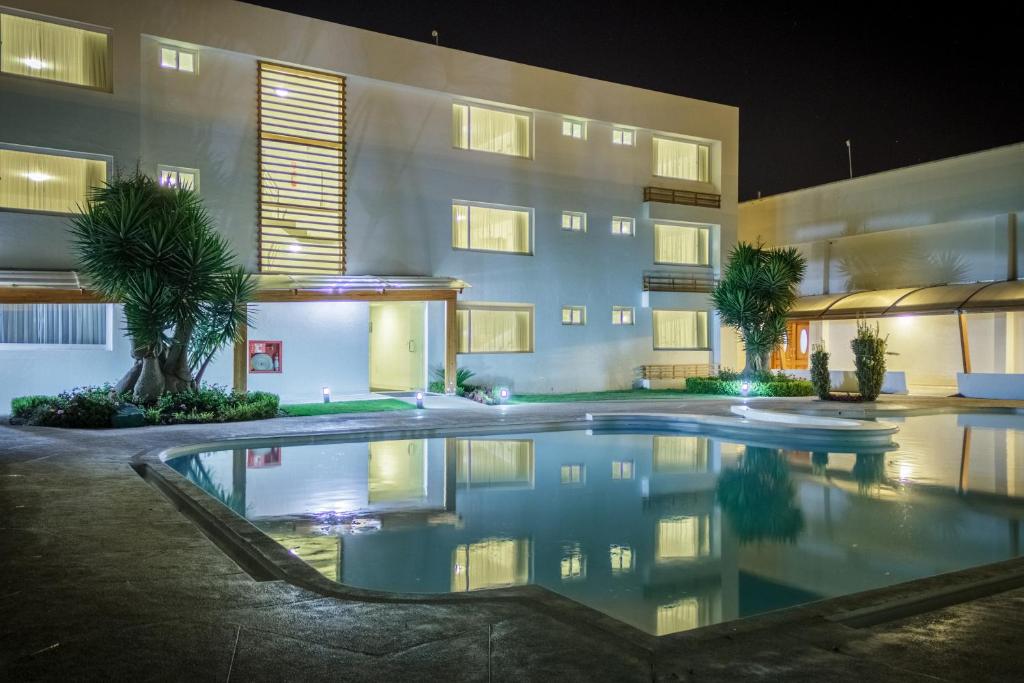 a swimming pool in front of a building at night at Hotel Ajavi in Ibarra