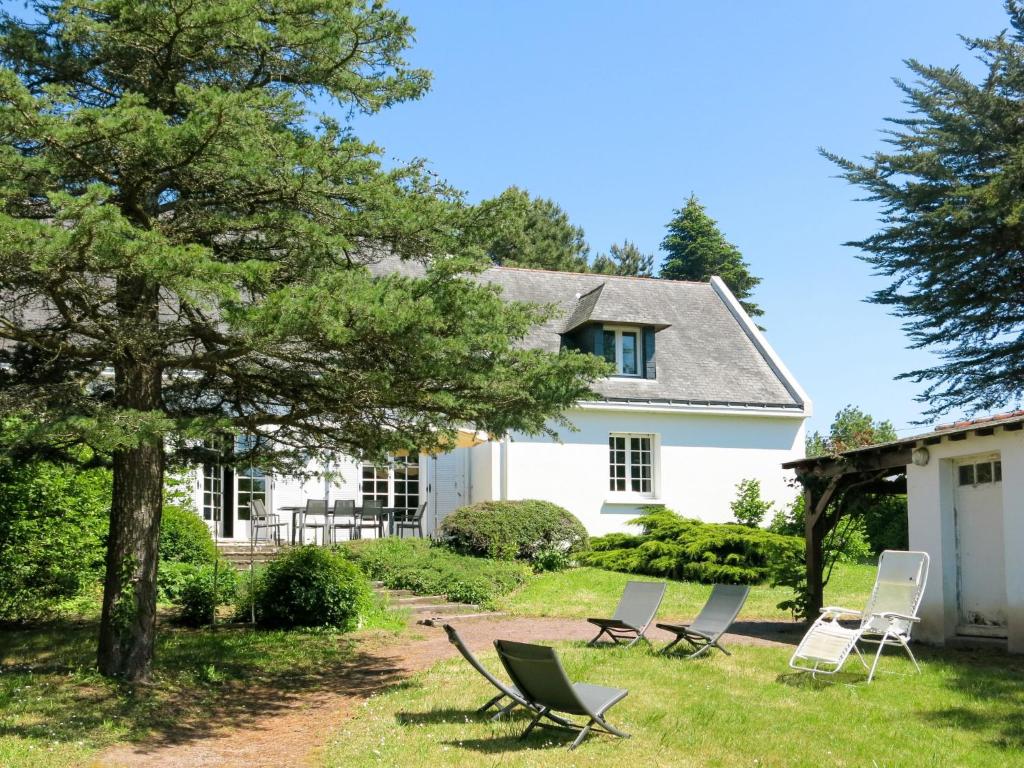 una casa bianca con sedie da giardino di fronte di Holiday Home Stergann by Interhome a Mesquer