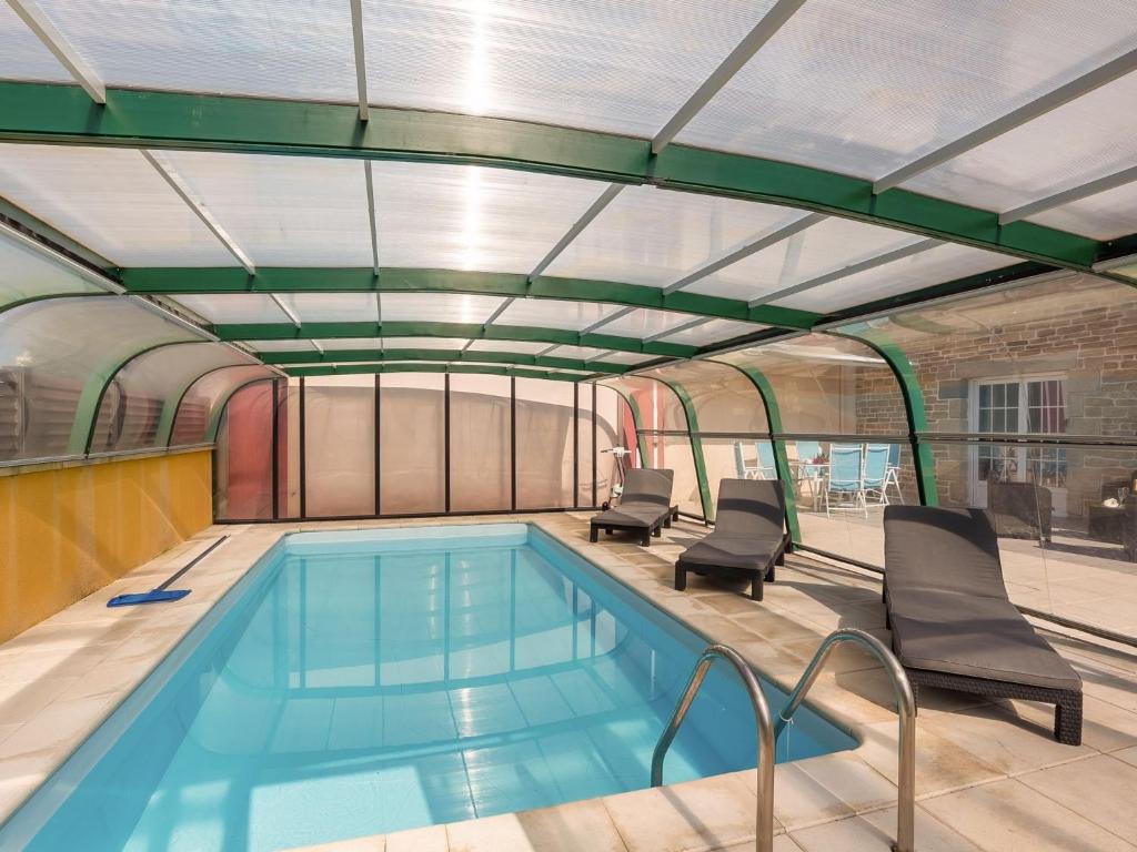 une piscine avec deux chaises et une piscine dans l'établissement Holiday Home Villa Mor-Eol by Interhome, à Plounéour-Trez