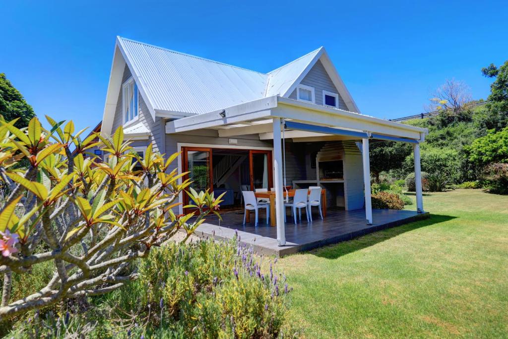 a house with a deck with a table and chairs at Frederik Ave in Wilderness