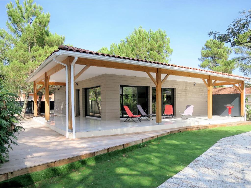 un pavillon avec des chaises sur une terrasse en bois dans l'établissement Holiday Home Yara by Interhome, à Lacanau