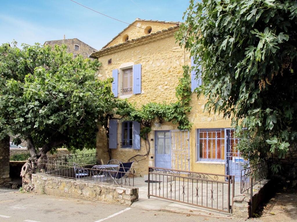 a house with a table and chairs in front of it at Holiday Home La Maison du Figuier by Interhome in Saint-Montan