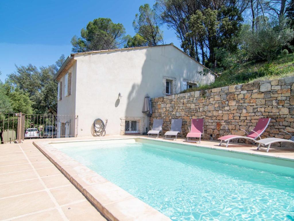 une maison avec piscine à côté d'un mur de pierre dans l'établissement Holiday Home Les Restanques by Interhome, à Carcès