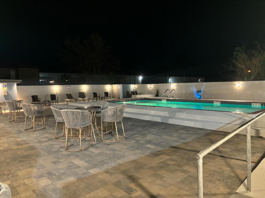布朗斯维尔Deluxe Inn & Suites的游泳池旁的游泳池配有桌椅
