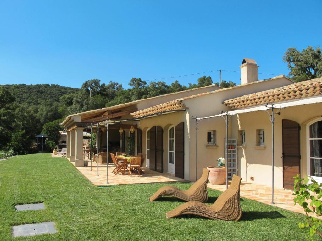a house with two chairs in the yard at Holiday Home Le Mas de la Roche by Interhome in La Môle