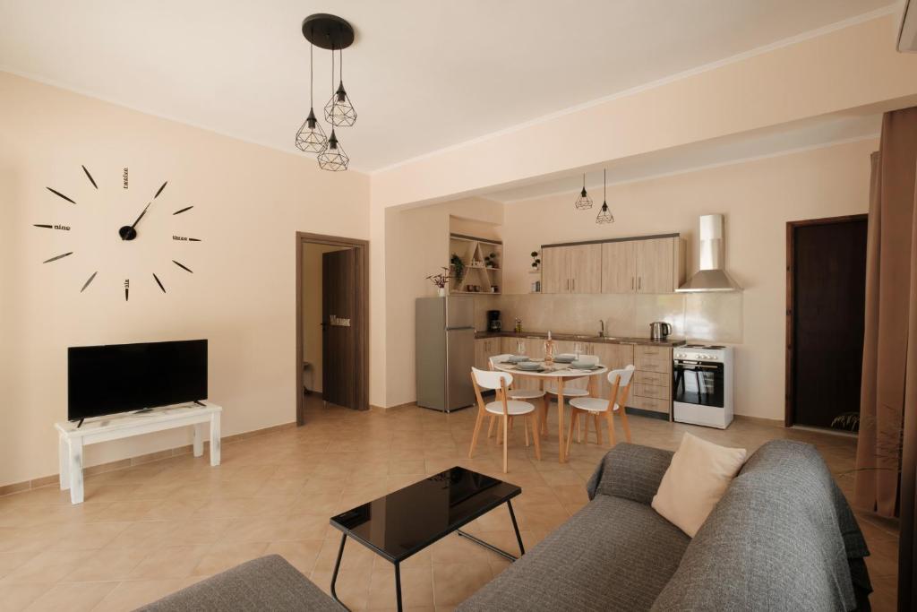 a living room with a couch and a clock on the wall at Agatha's spacious modern apt-1 in Perítheia