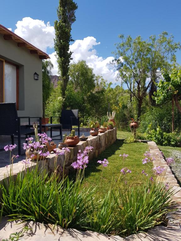a garden with a table and some flowers at Tierra Primitiva in Tilcara