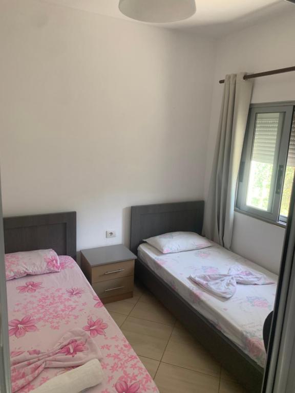a bedroom with two beds and a window at Villas Ermali in Ksamil
