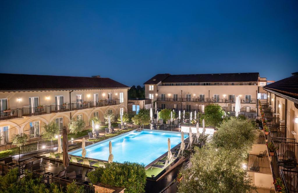 una piscina all'aperto in un cortile di due edifici di Leonardo Hotel Lago di Garda - Wellness and Spa a Lazise