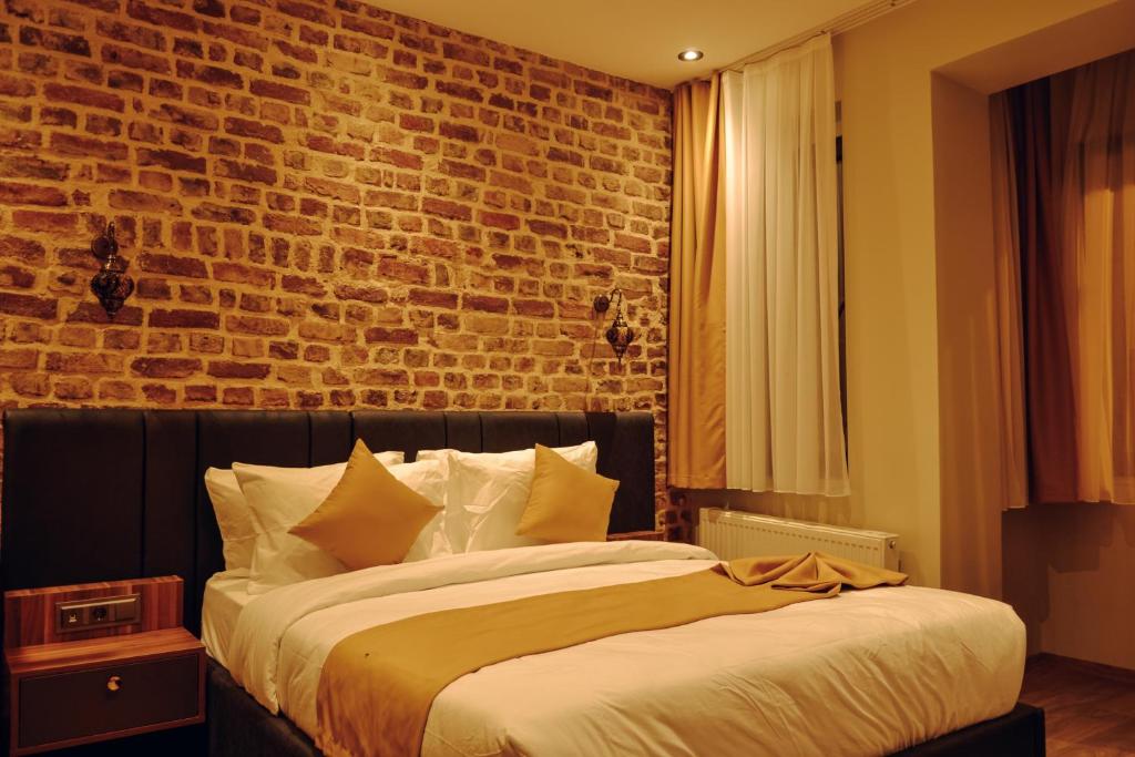 ein Schlafzimmer mit einem großen Bett mit Ziegelwand in der Unterkunft Galata Calm Tale Hotel in Istanbul