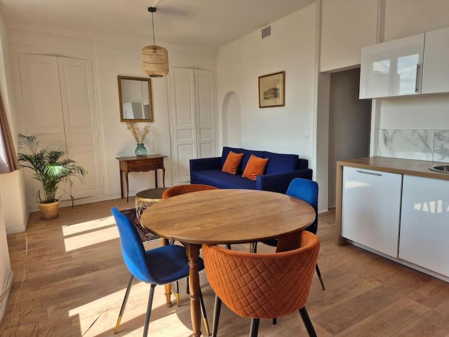 un salon avec une table et des chaises bleues dans l'établissement Le prospère - wifi - central, à Angers