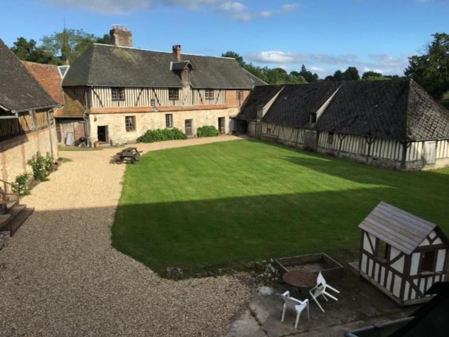 une vue aérienne sur une grande cour avec des bâtiments dans l'établissement La Ferme du Chateau, à Fauguernon