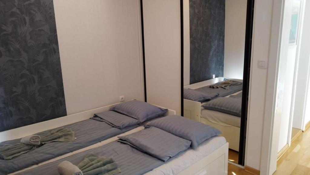 a bedroom with two beds and a mirror at Royal Villa - HAWAII in Vrnjačka Banja