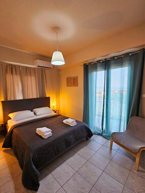 a bedroom with a bed and a chair and a window at VMA Residence in Artemida