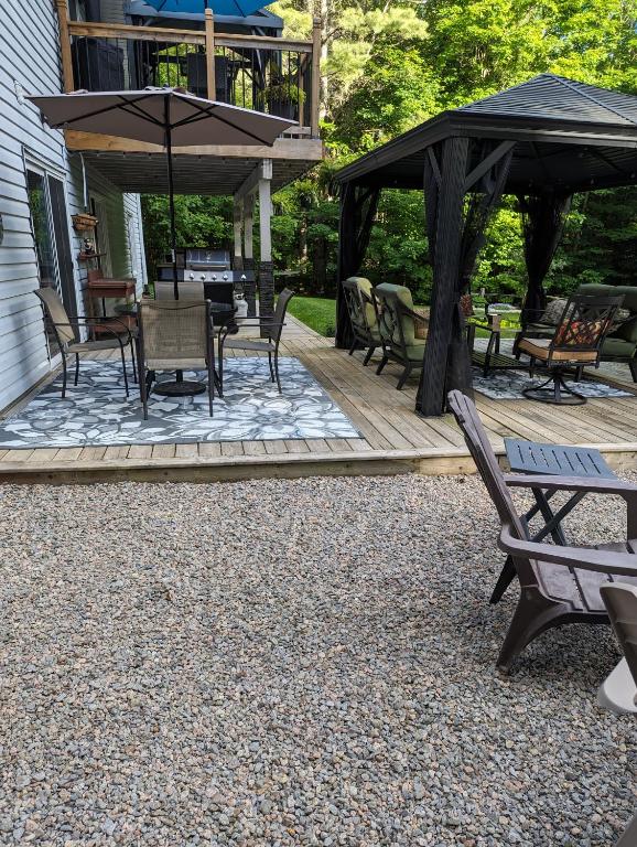 a patio with a gazebo and chairs and tables at Suite in the Bush-Private Apartment in Bancroft
