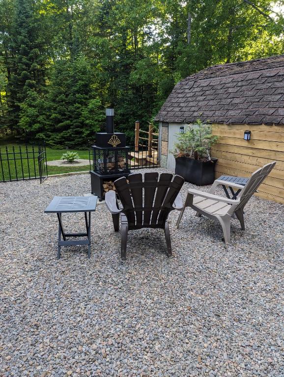 a patio with two chairs and a table and a grill at Suite in the Bush-Private Apartment in Bancroft