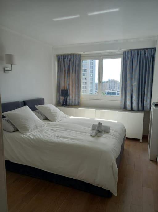 une chambre avec un grand lit et une fenêtre dans l'établissement Superbe appartement à Paris, à Puteaux