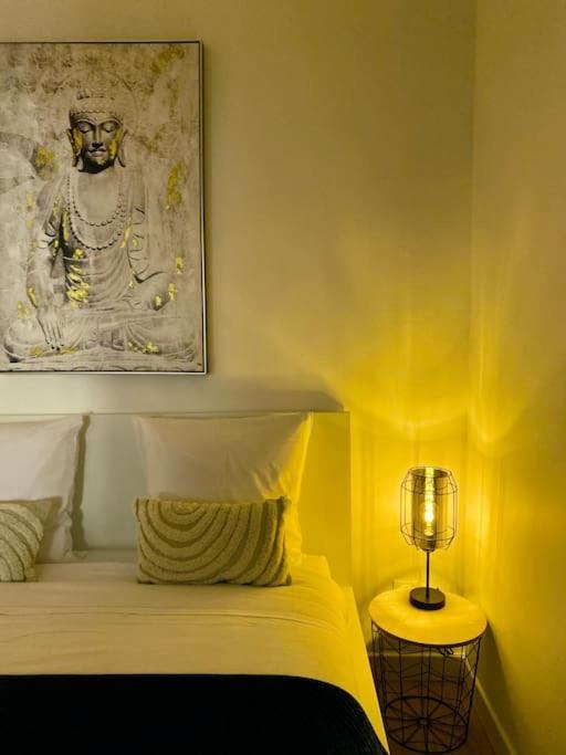 une chambre avec un lit avec un tableau sur le mur dans l'établissement ''Lotus'' Superbe T2 centre ville climatisé - Wifi, à Sète