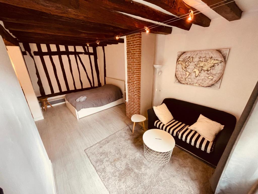 - un petit salon avec un canapé et un lit dans l'établissement Le studio la belle et la bete -326, à Rouen