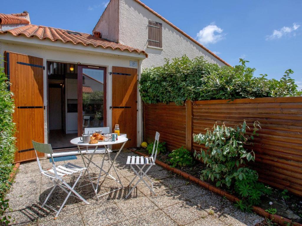 une terrasse avec une table et des chaises à côté d'une clôture dans l'établissement Holiday Home Plein Océan-3 by Interhome, à Pornic