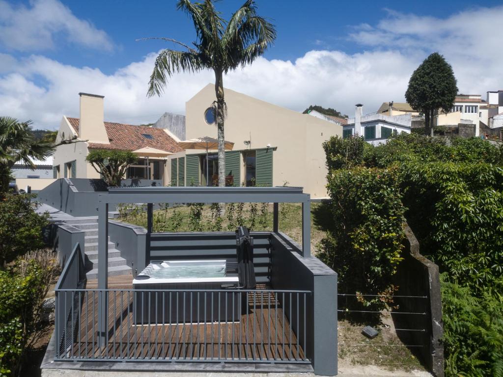 a staircase leading to a house with a palm tree at Casa nas Caldeiras in Furnas