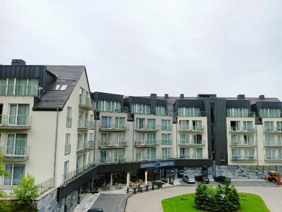 シェンナにあるApartament Czarna Góra STARの大きな窓のある大きなアパートメントビル