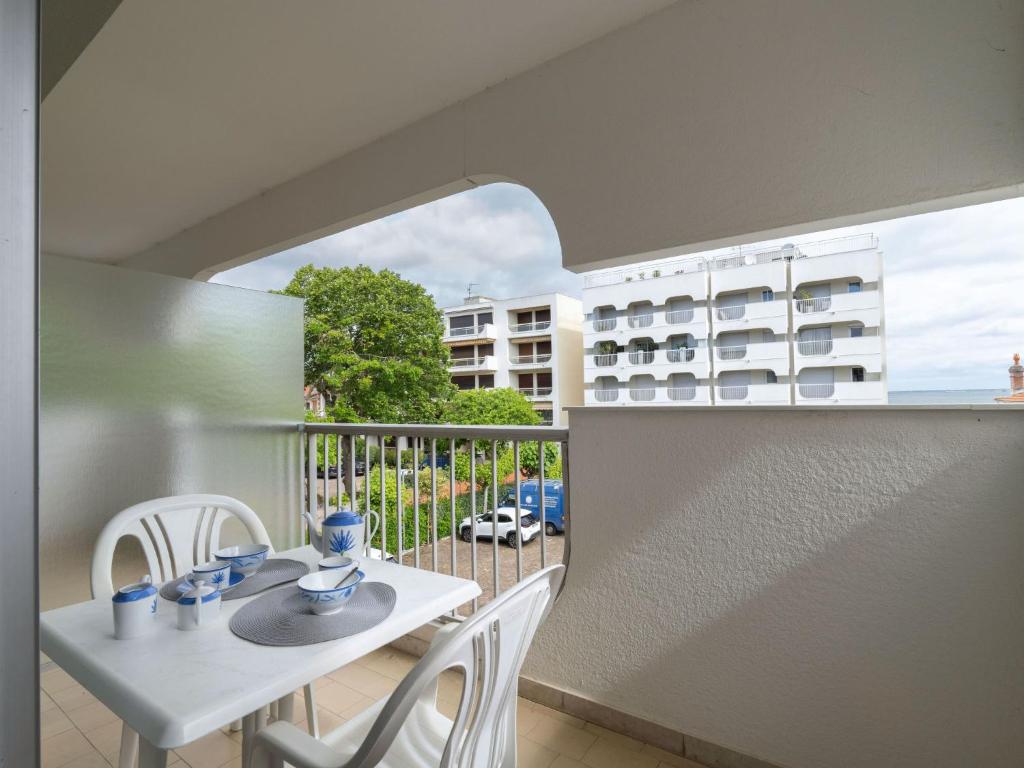 Il dispose d'un balcon avec une table et des chaises blanches. dans l'établissement Studio Bailli de Suffren-3 by Interhome, à Arcachon