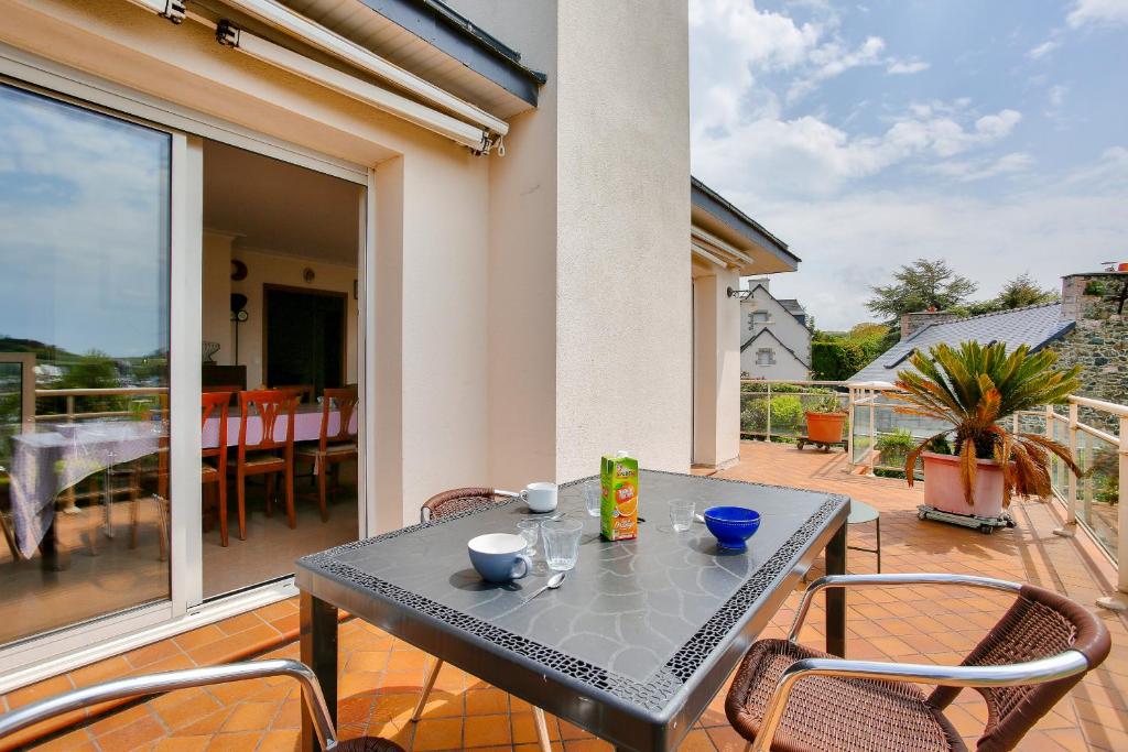 un patio avec une table et des chaises sur un balcon dans l'établissement Maison pour 8 avec jardin avec vue sur le port, à Pléneuf-Val-André