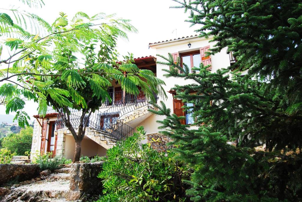 ein Gebäude mit einem Balkon und Bäumen davor in der Unterkunft Hanna House in Kato Trikala Korinthias
