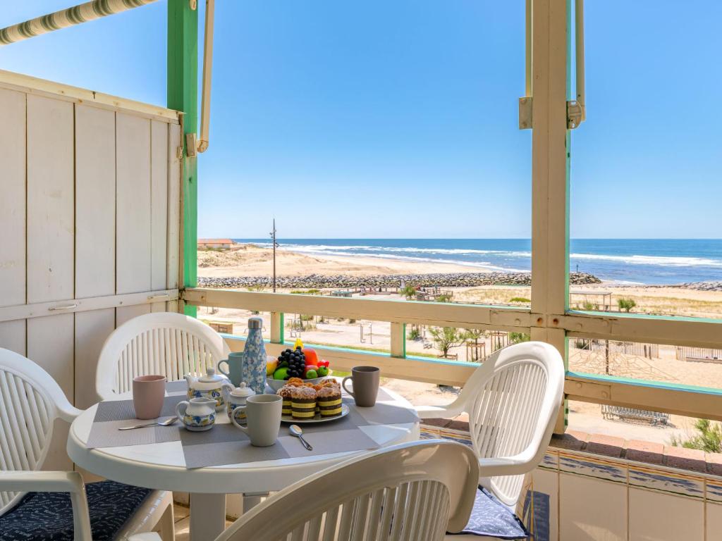 une table et des chaises sur un balcon avec vue sur la plage dans l'établissement Apartment Cap Océan-8 by Interhome, à Mimizan