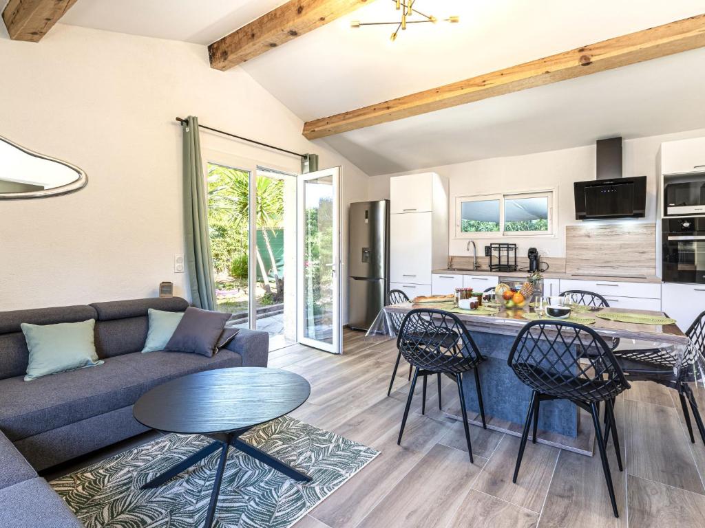 a living room with a couch and a table and chairs at Holiday Home Casa Germaine by Interhome in Porto-Vecchio