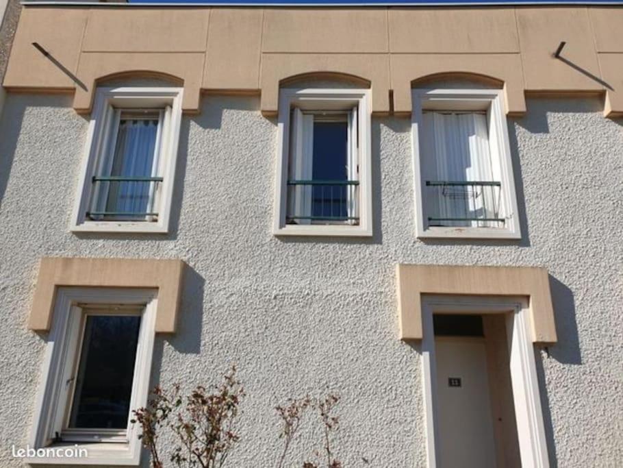 a building with four windows and a door at Maison de ville 102m2 3 chambres in Montigny-le-Bretonneux