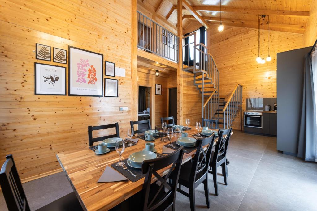a dining room with a long wooden table and chairs at Drvena bajka Ville za odmor Magnolia i Kamelia in Bilje