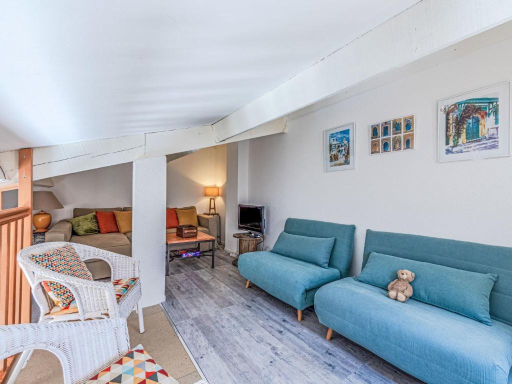 - un salon avec un canapé bleu et un lit dans l'établissement Holiday Home Les Brigantines 1 et 2-6 by Interhome, à Saint-Cyprien