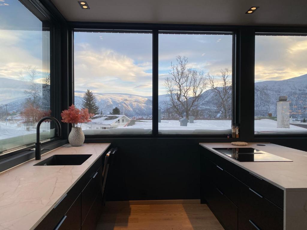 a kitchen with two sinks and a large window at Panorama view apartment in Tromsø