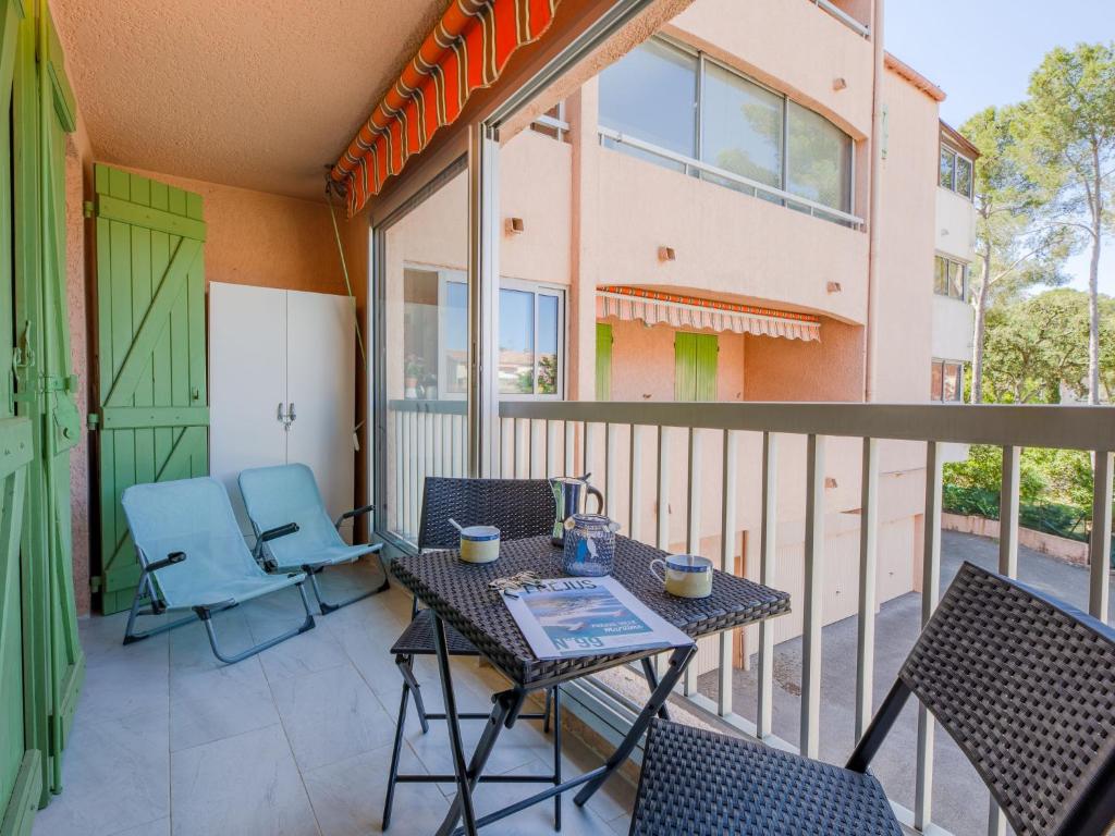 un patio avec une table et des chaises sur un balcon dans l'établissement Apartment Lou Gabian-2 by Interhome, à Saint-Aygulf