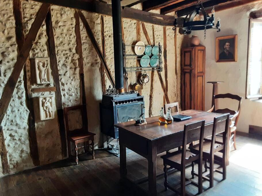 a dining room with a wooden table and a stove at Gîte Dűrer in Fanjeaux