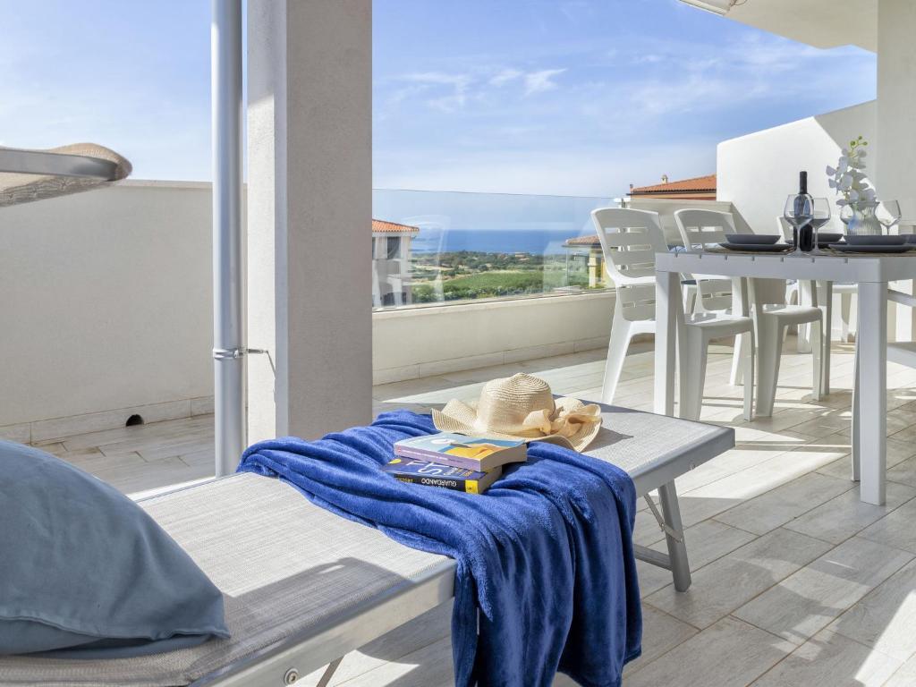 Una toalla en un banco en un balcón con una mesa. en Apartment Alta Marea by Interhome, en Valledoria