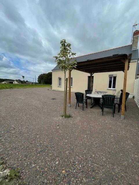 un pavillon avec une table, des chaises et un arbre dans l'établissement Maison de campagne 