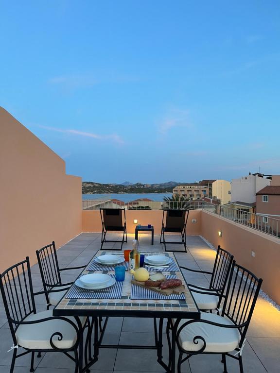 un patio avec une table et des chaises sur un balcon dans l'établissement La Terrasse - Appartamento L'Orso, Terazzo vista mare, à La Maddalena