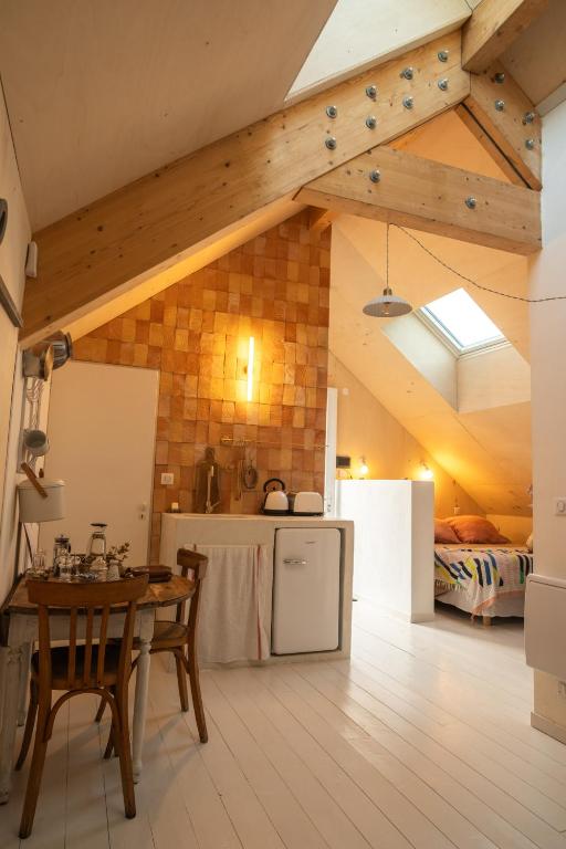 une cuisine avec une table et une chambre avec un lit dans l'établissement Maison Mandavi, studio d'hôtes dans l'Entre deux mers, à Loupes