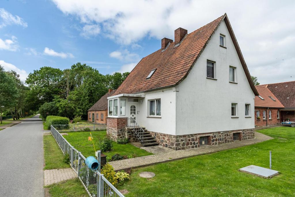 a white house with a red roof at Ferienwohnung auf dem Land in Altenwillershagen